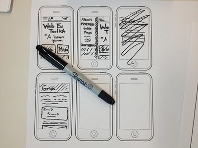 design sketches in sharpie on the repeated outline of a phone, showing headings, menus, and cross-outs